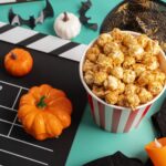 Movie,Clapperboard,And,Halloween,Decorations,With,Popcorn,On,Green,Background,